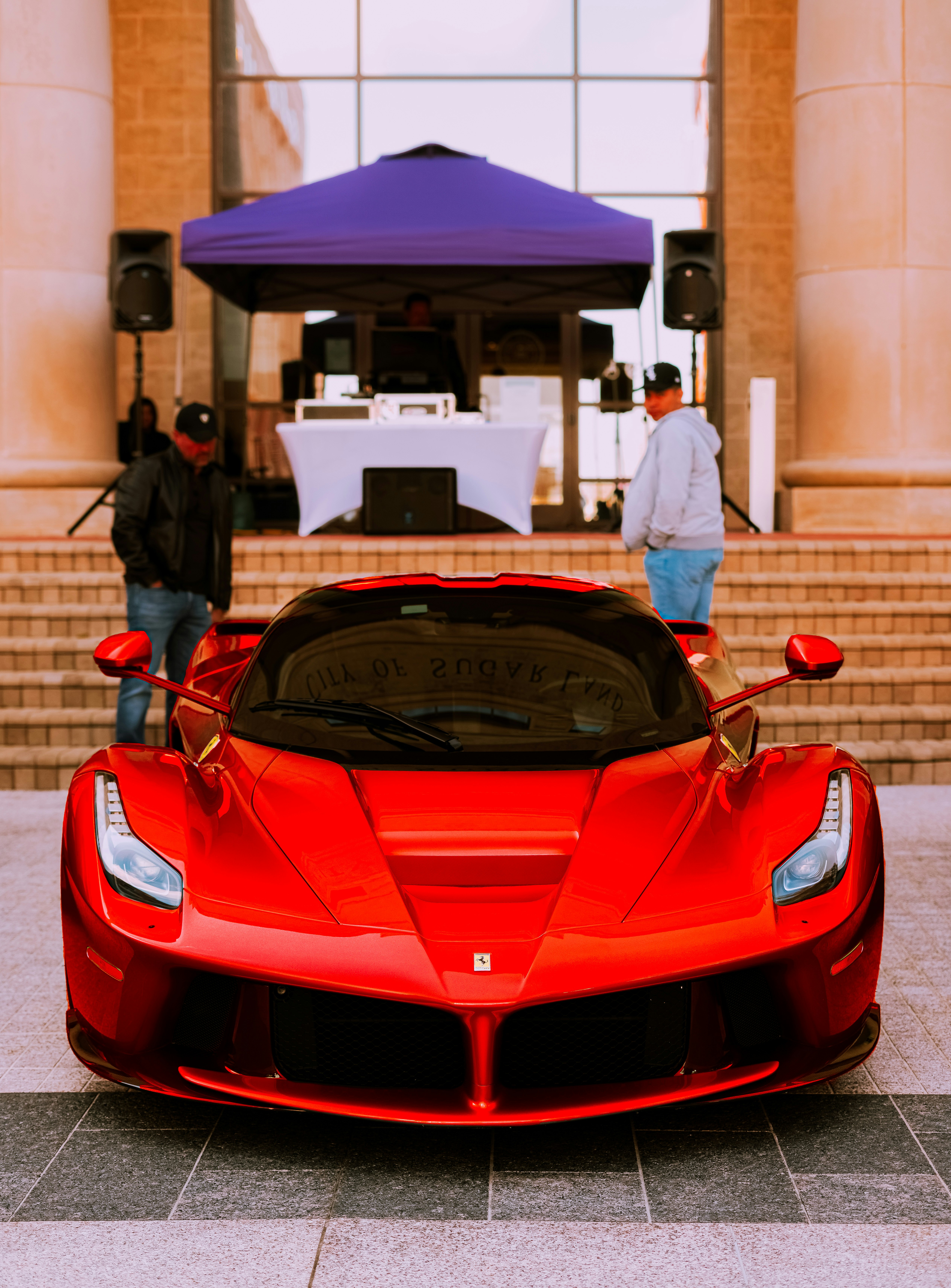 red ferrari sports car in front of people walking on street during daytime